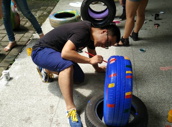图三：服务队队员为幼儿园基础建设的轮胎主题进行装饰绘画.jpg